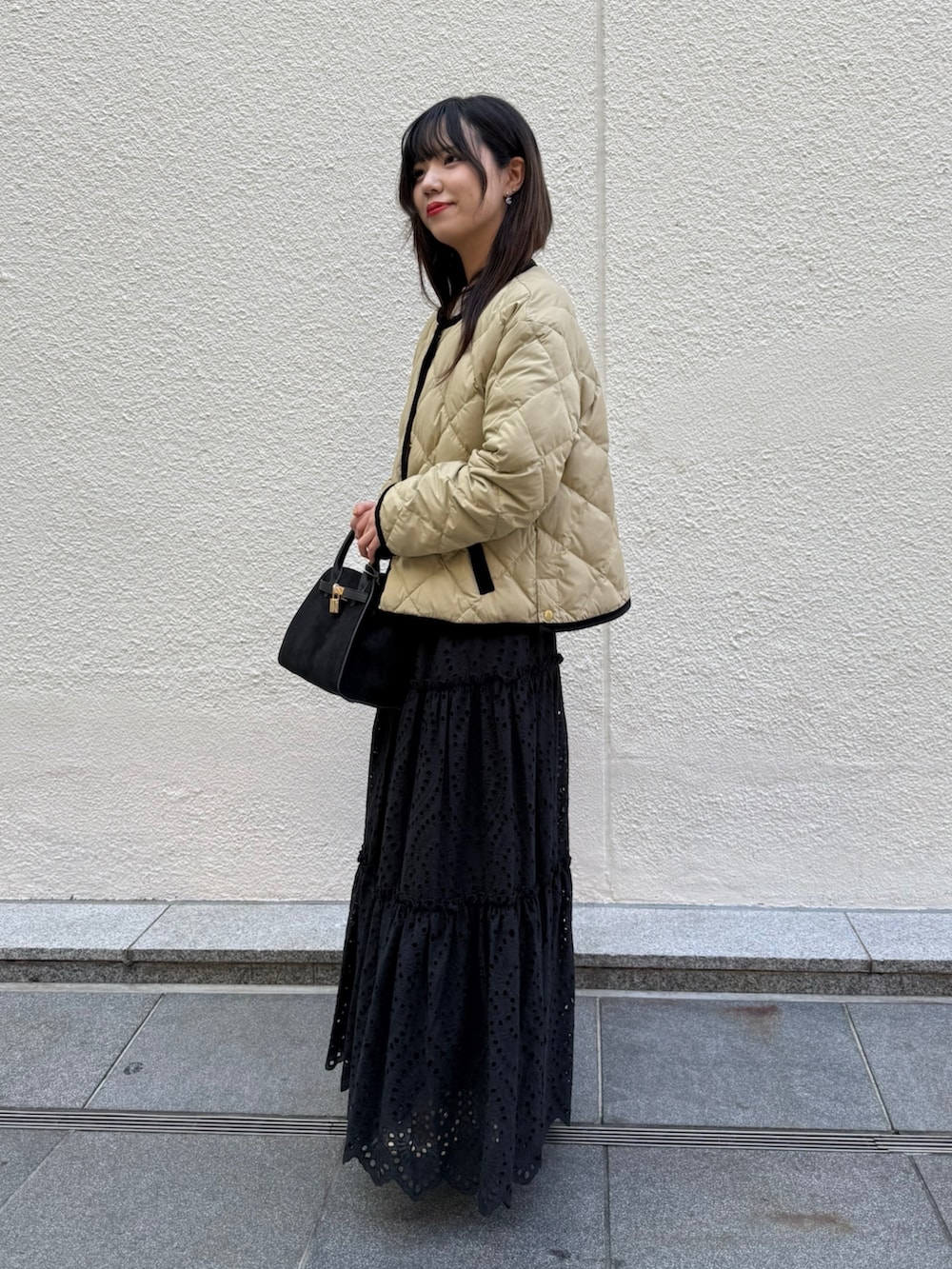 ホワイト系のニット/セーター、ブラック系のスカート、ブラック系のトートバッグを着用したレディースの秋コーディネートの2枚目の写真