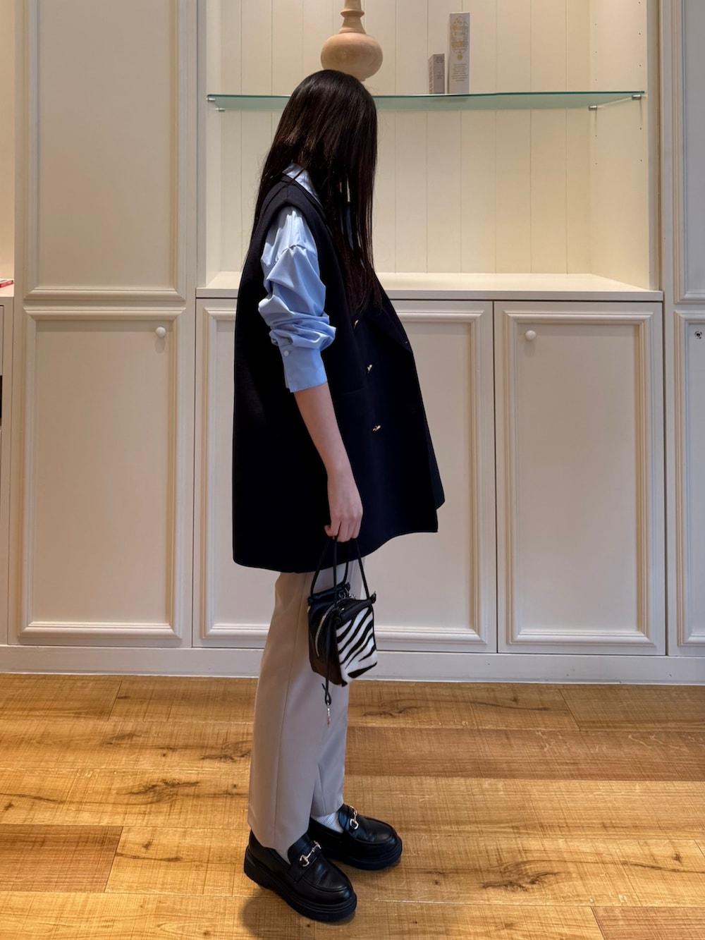 ブルー系のシャツ/ブラウス、ブルー系のベスト、ベージュ系のその他パンツを着用したレディースの秋コーディネートの2枚目の写真