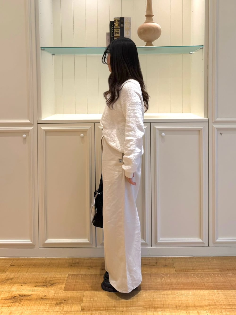 ホワイト系のニット/セーター、ホワイト系のその他パンツ、ブラック系のショルダーバッグを着用したレディースの春コーディネートの4枚目の写真