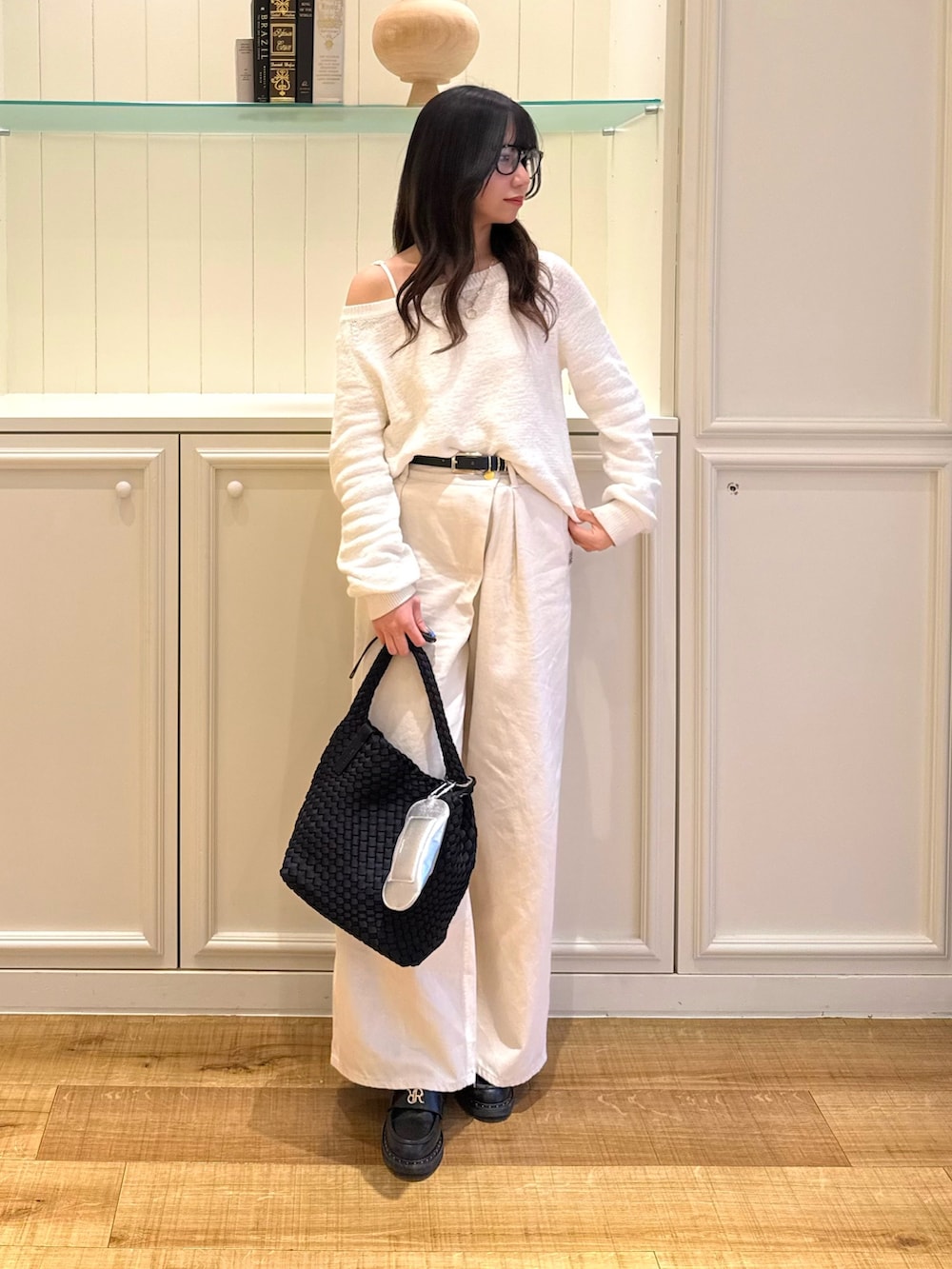 ホワイト系のニット/セーター、ホワイト系のその他パンツ、ブラック系のショルダーバッグを着用したレディースの春コーディネートの5枚目の写真