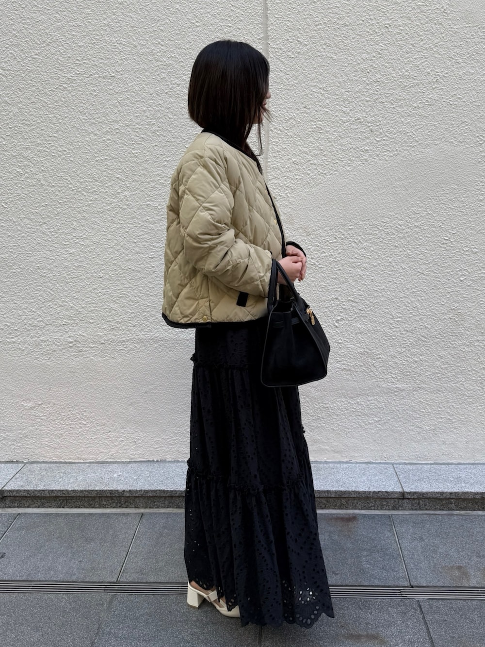 ホワイト系のニット/セーター、ブラック系のスカート、ブラック系のトートバッグを着用したレディースの秋コーディネートの4枚目の写真