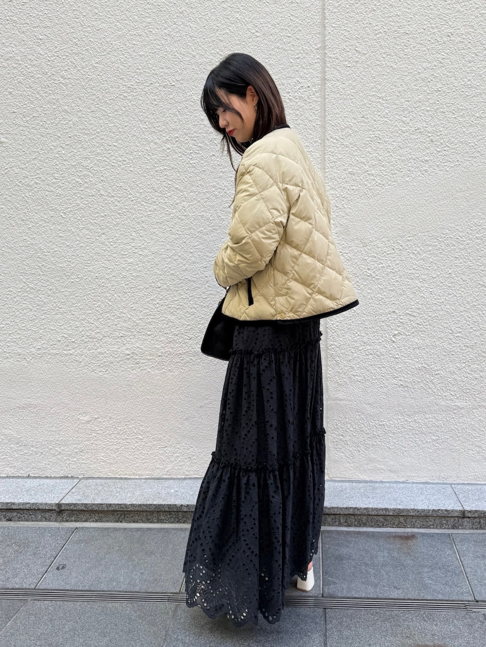 ホワイト系のニット/セーター、ブラック系のスカート、ブラック系のトートバッグを着用したレディースの秋コーディネートの5枚目の写真