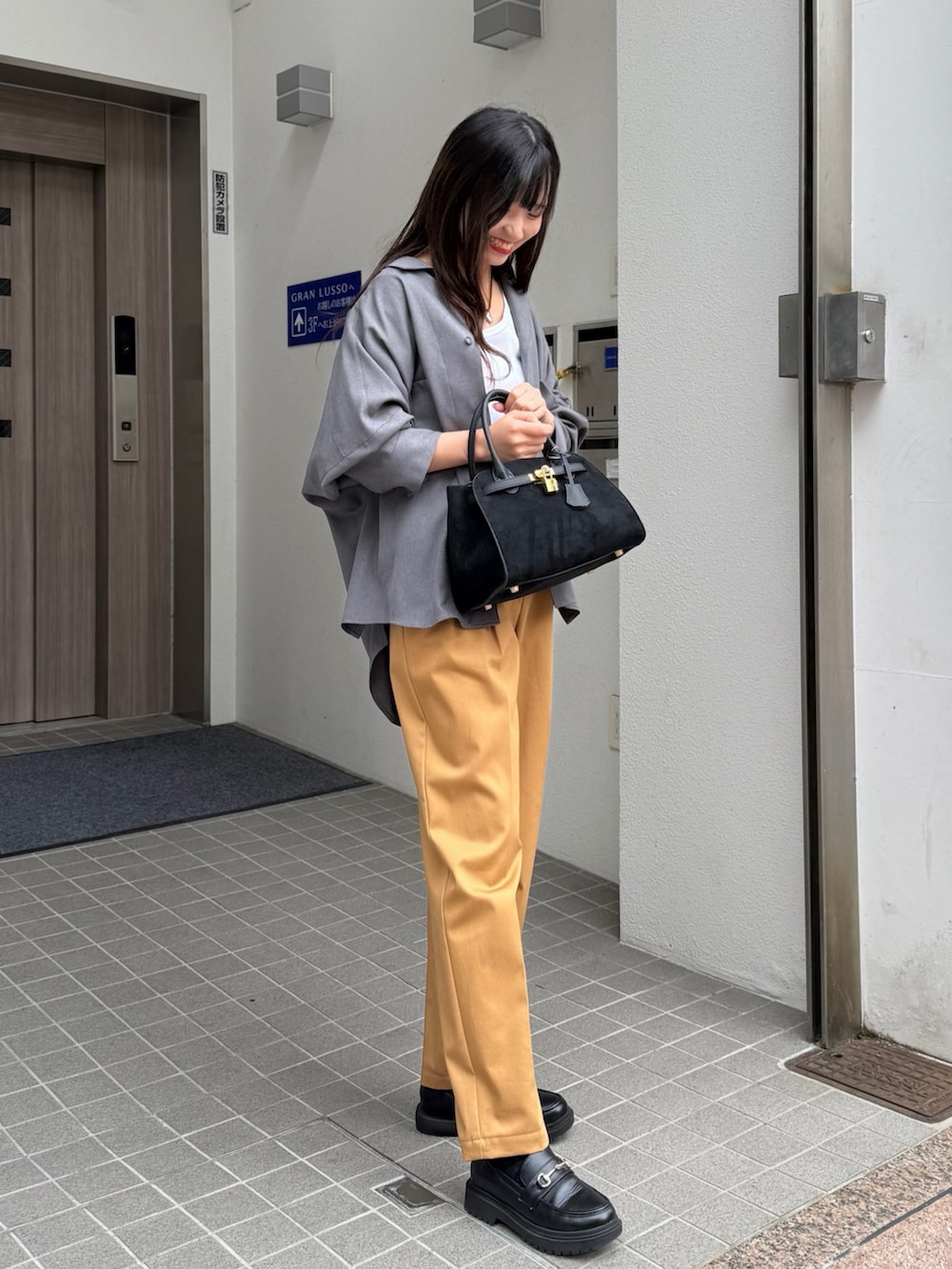 グレー系のシャツ/ブラウス、ブラック系のトートバッグ、イエロー系のその他パンツを着用したレディースの秋コーディネートの2枚目の写真