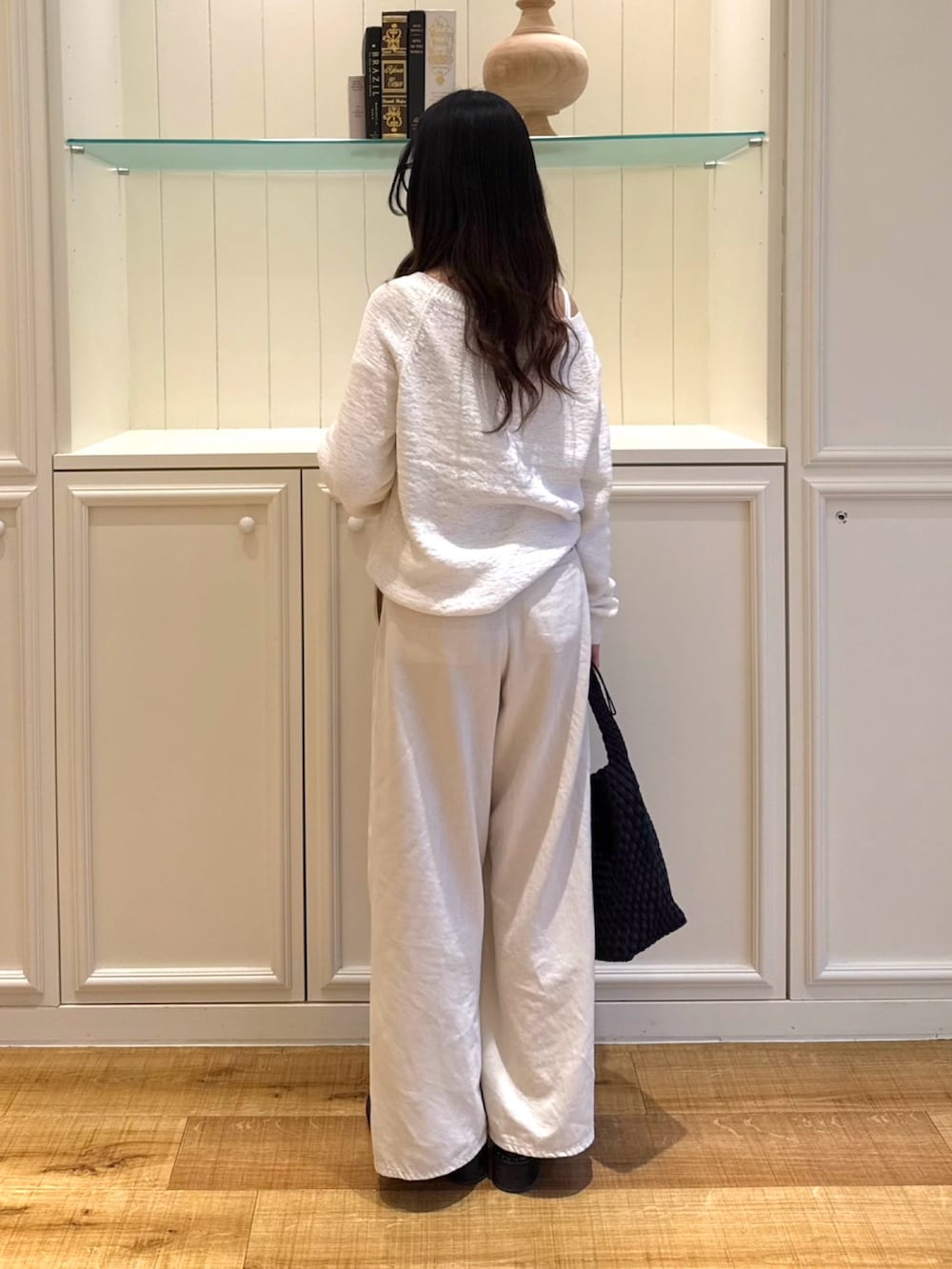 ホワイト系のニット/セーター、ホワイト系のその他パンツ、ブラック系のショルダーバッグを着用したレディースの春コーディネートの3枚目の写真