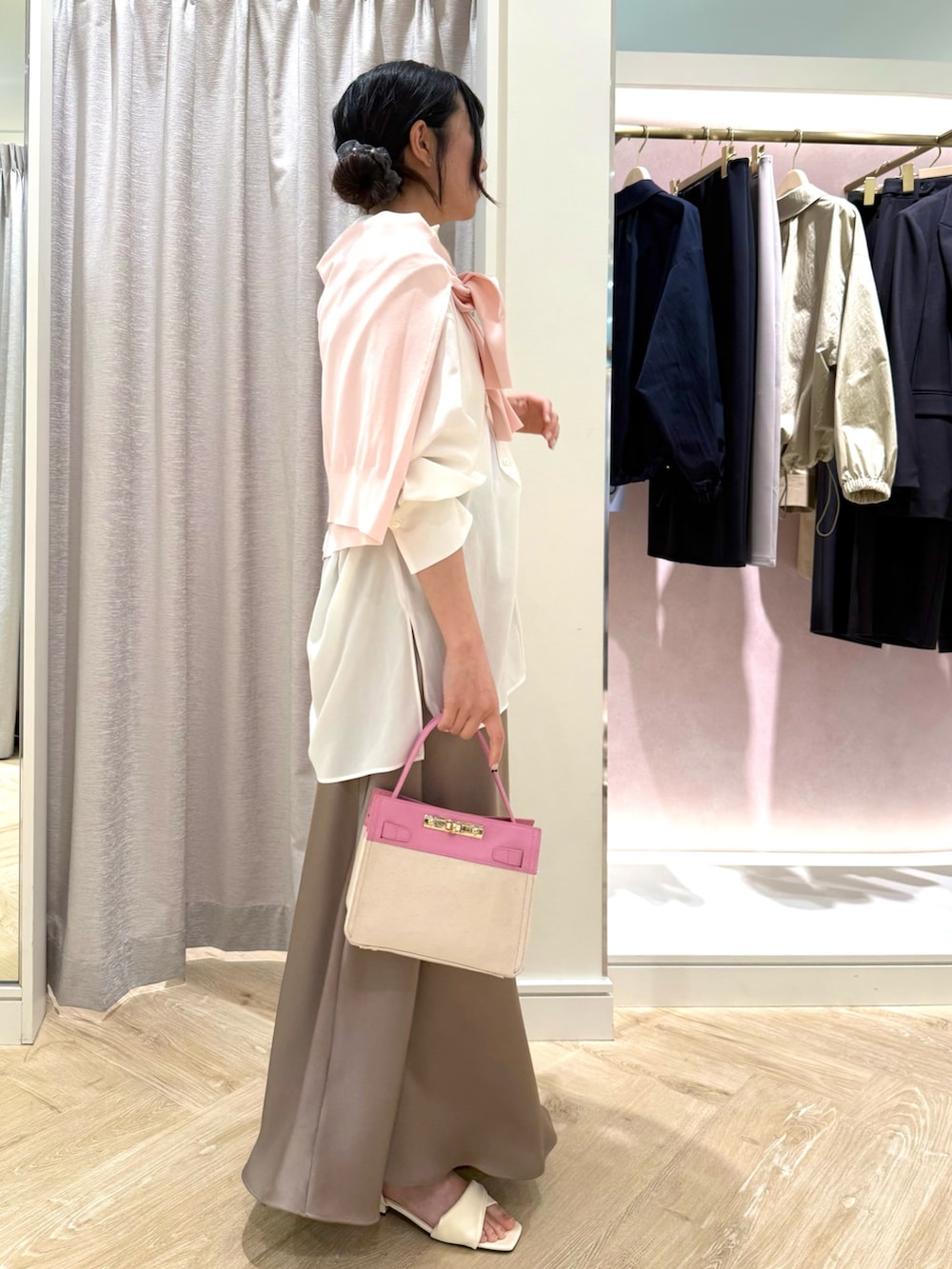 ピンク系のショルダーバッグ、ピンク系のカーディガン/ボレロ、ホワイト系のシャツ/ブラウスを着用したレディースの春コーディネートの2枚目の写真