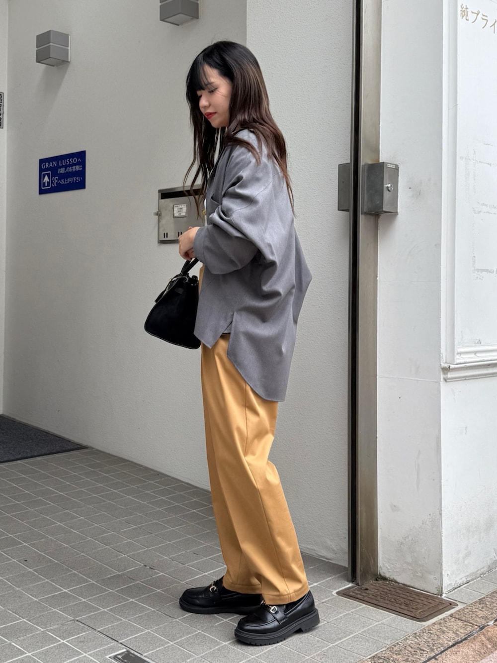 グレー系のシャツ/ブラウス、ブラック系のトートバッグ、イエロー系のその他パンツを着用したレディースの秋コーディネートの4枚目の写真