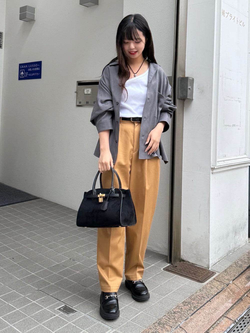 グレー系のシャツ/ブラウス、ブラック系のトートバッグ、イエロー系のその他パンツを着用したレディースの秋コーディネートの6枚目の写真