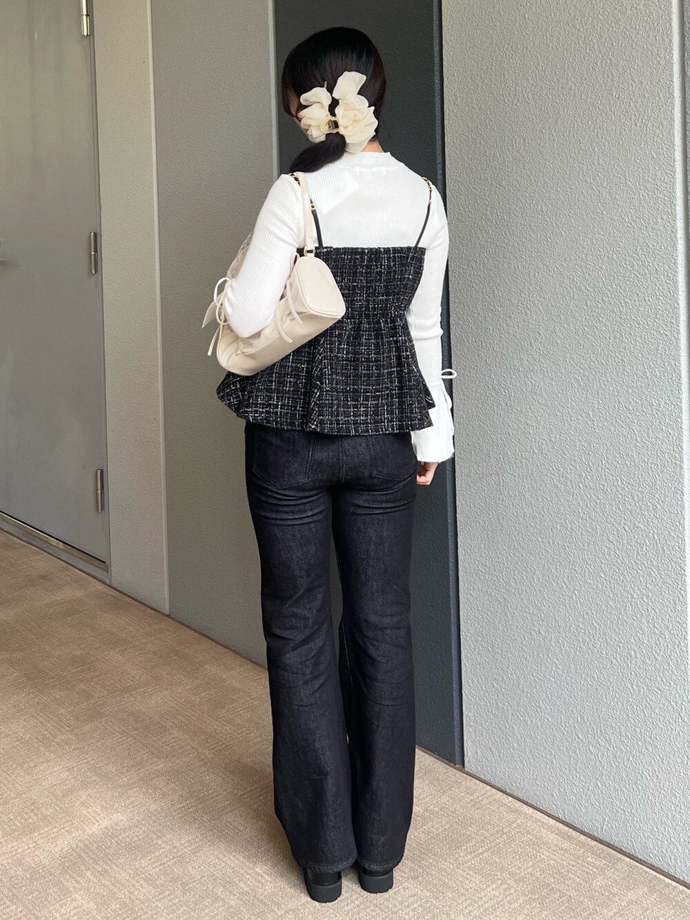 ホワイト系のニット/セーター、ブラック系のタンクトップ、ブラック系のデニムパンツを着用したレディースの秋コーディネートの3枚目の写真