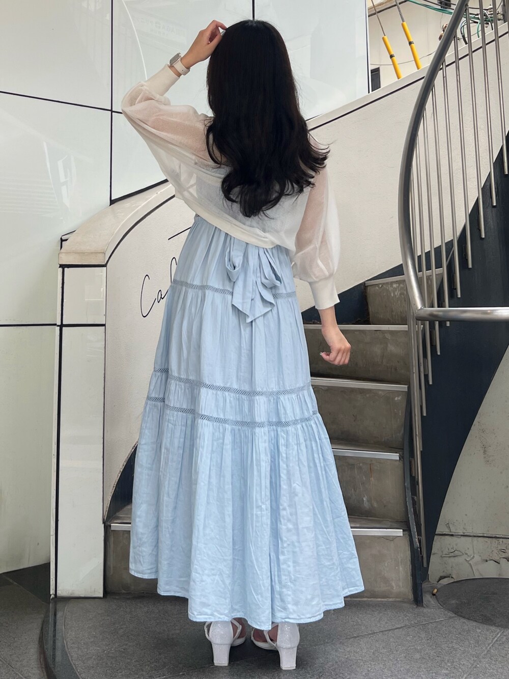 ブルー系のワンピース、ホワイト系のカーディガン/ボレロ、ホワイト系のサンダルを着用したレディースの夏コーディネートの3枚目の写真