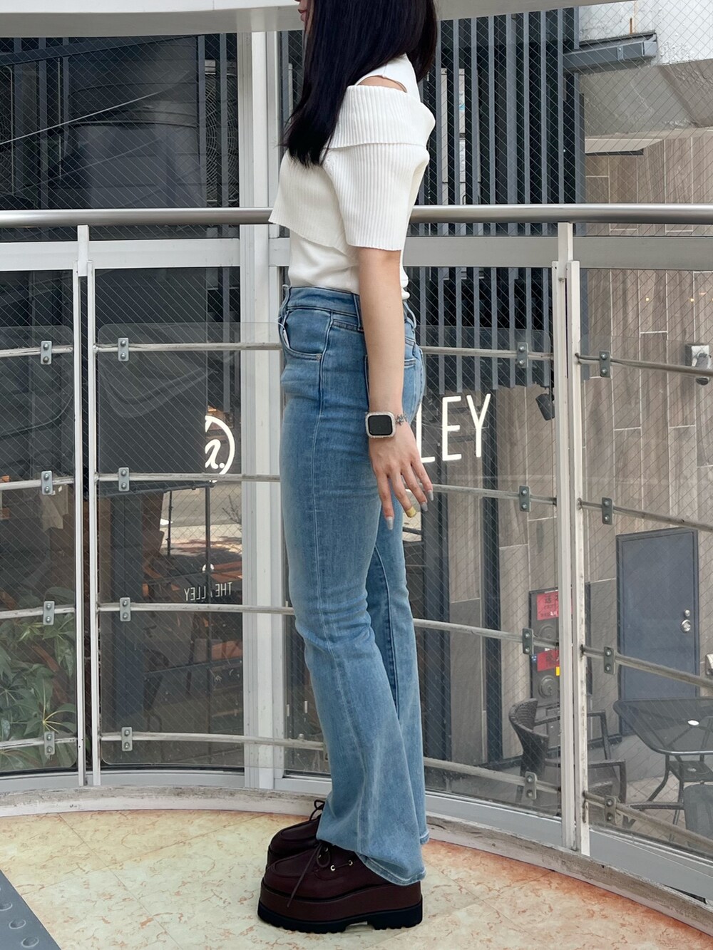 ホワイト系のニット/セーター、ブルー系のデニムパンツ、ブラウン系のローファーを着用したレディースの秋コーディネートの2枚目の写真