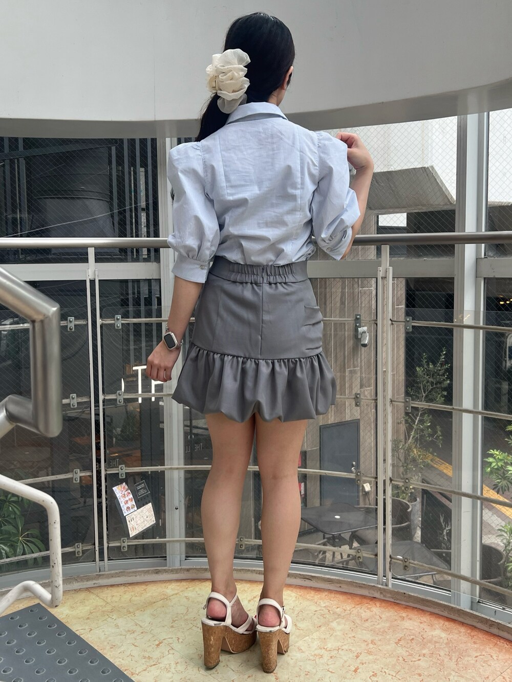 ブルー系のシャツ/ブラウス、グレー系のスカート、ホワイト系のサンダルを着用したレディースの夏コーディネートの3枚目の写真
