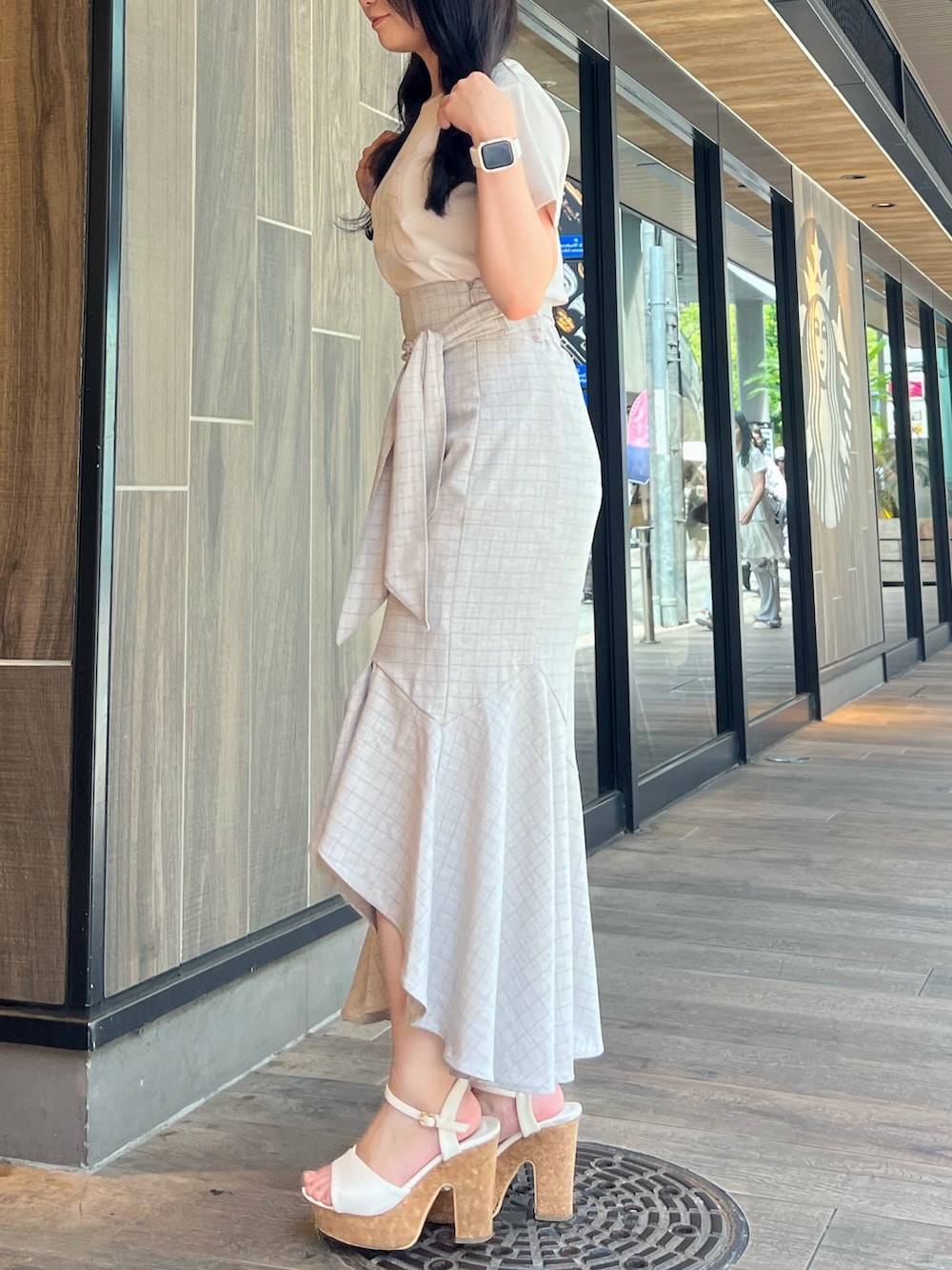 ベージュ系のスカート、グレー系のTシャツ/カットソー、ホワイト系のサンダルを着用したレディースの夏コーディネートの3枚目の写真