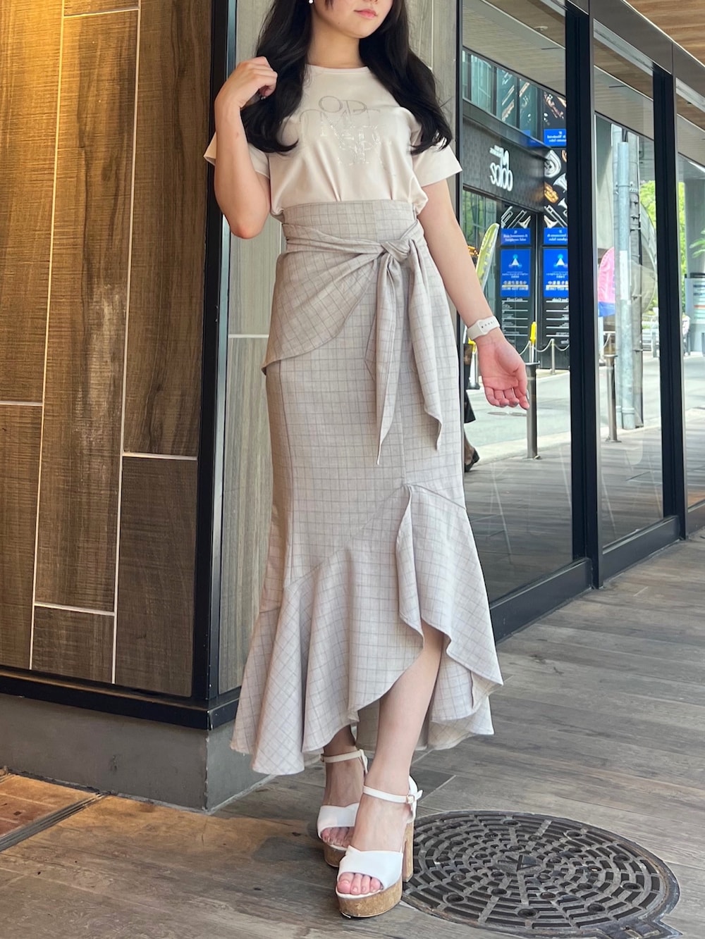 ベージュ系のスカート、グレー系のTシャツ/カットソー、ホワイト系のサンダルを着用したレディースの夏コーディネートの4枚目の写真