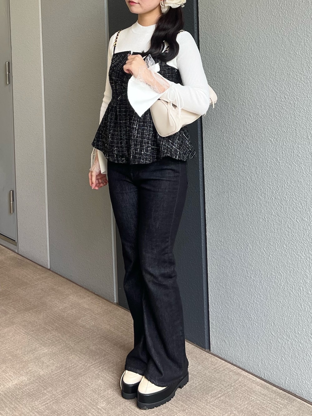 ホワイト系のニット/セーター、ブラック系のタンクトップ、ブラック系のデニムパンツを着用したレディースの秋コーディネートの2枚目の写真