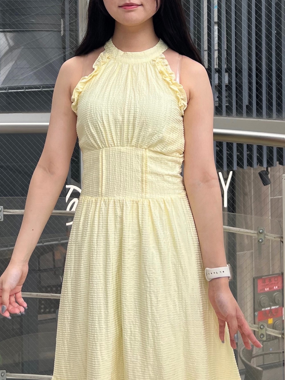 イエロー系のワンピース、ホワイト系のサンダルを着用したレディースの夏コーディネートの4枚目の写真