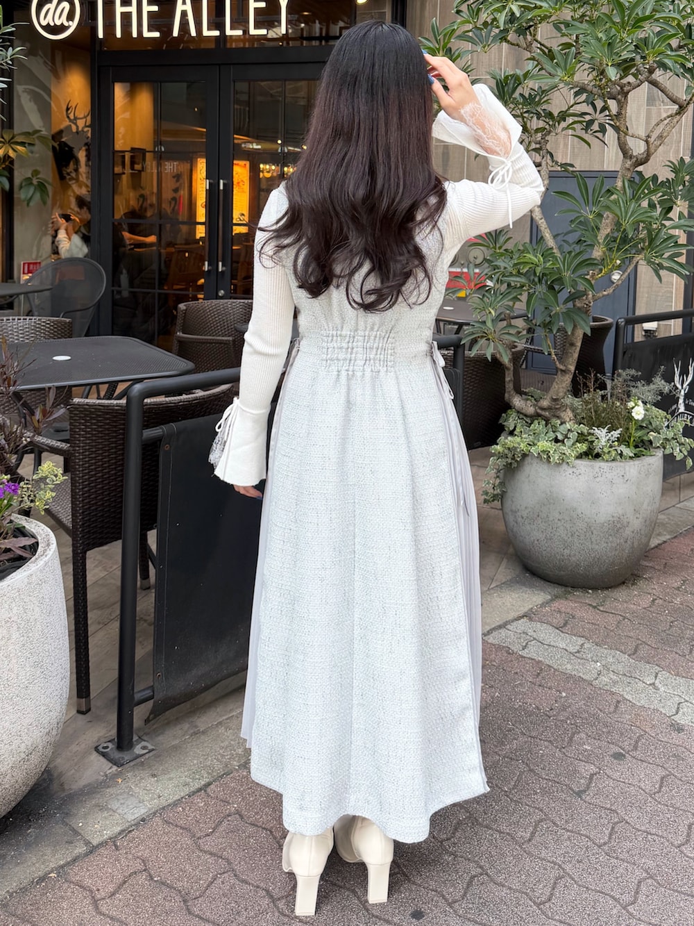 ホワイト系のブーツ、グレー系のワンピースを着用したレディースの春コーディネートの3枚目の写真