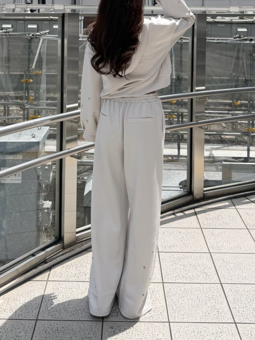ホワイト系のTシャツ/カットソー、ホワイト系のスウェットパンツ、ホワイト系のサンダルを着用したレディースの夏コーディネートの3枚目の写真