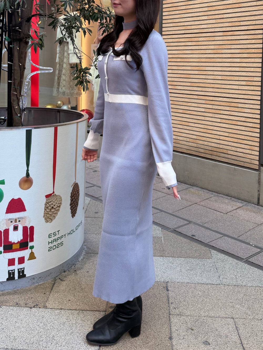 ブルー系のワンピース、ブラック系のブーツを着用したレディースの冬コーディネートの2枚目の写真