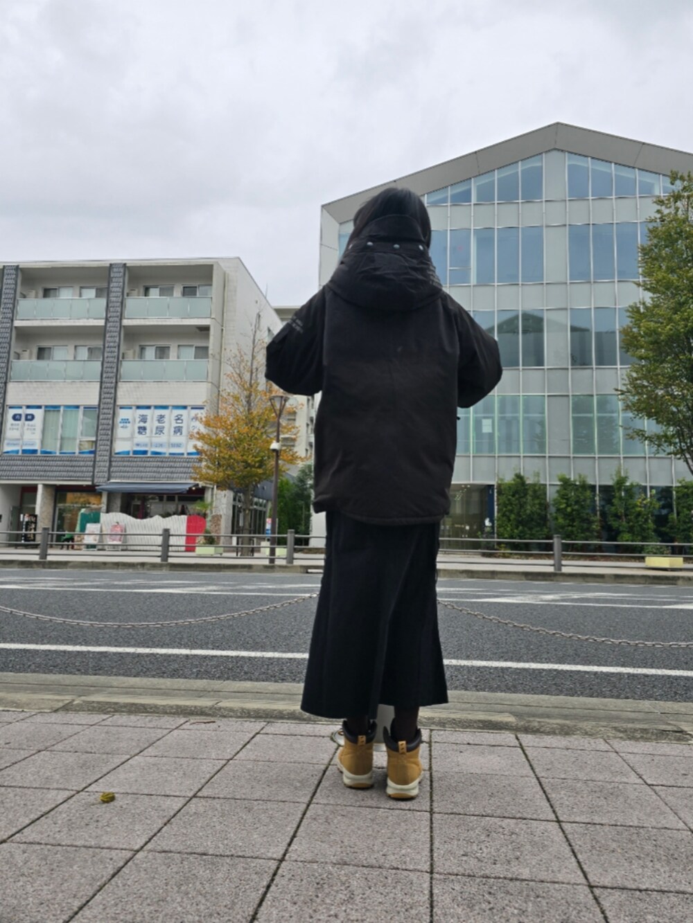 ブラック系のダウンジャケット/コート、ブラック系のスカートを着用したレディースの冬コーディネートの2枚目の写真