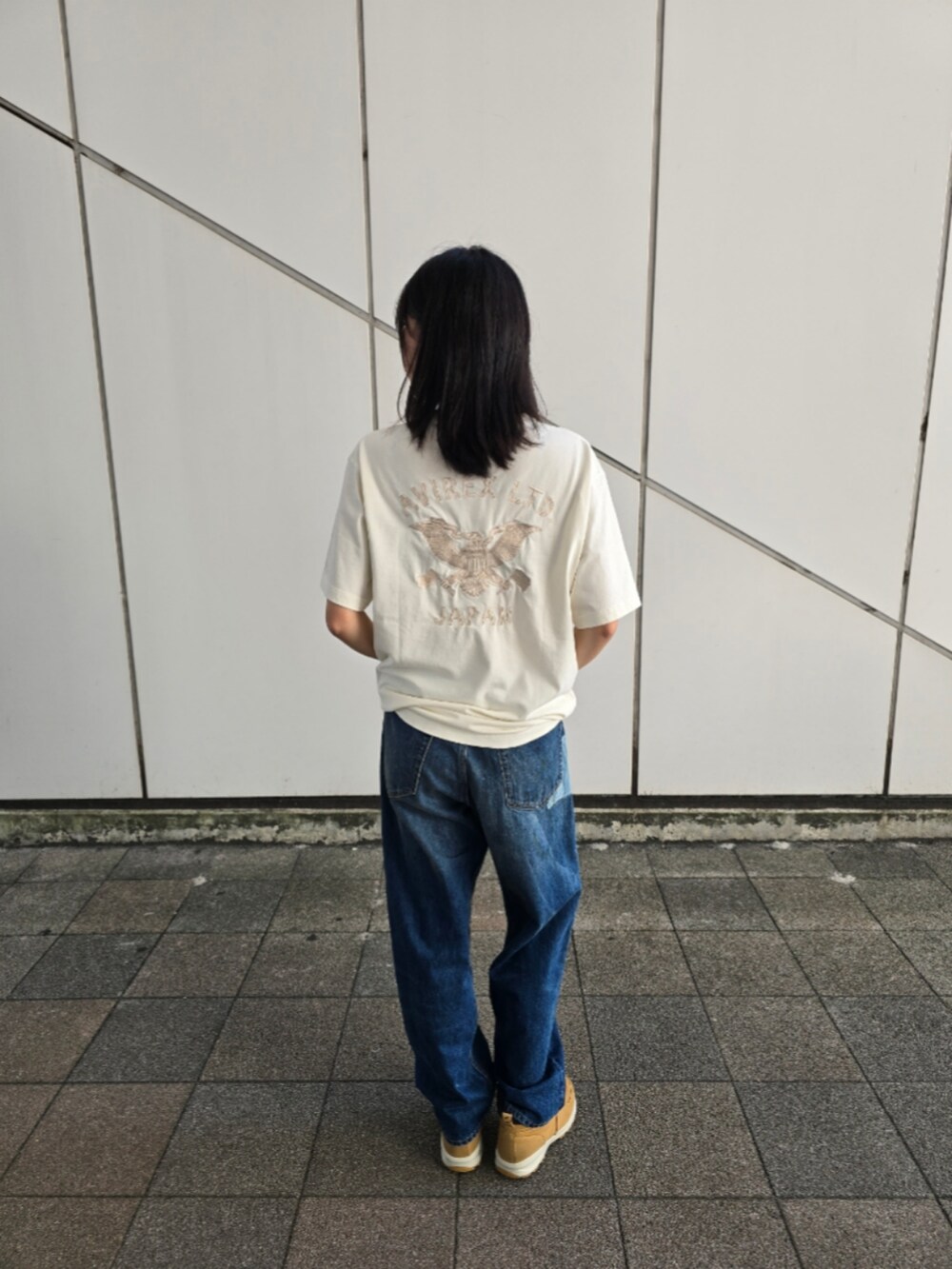 ブルー系のデニムパンツ、ホワイト系のTシャツ/カットソーを着用したレディースの夏コーディネートの2枚目の写真