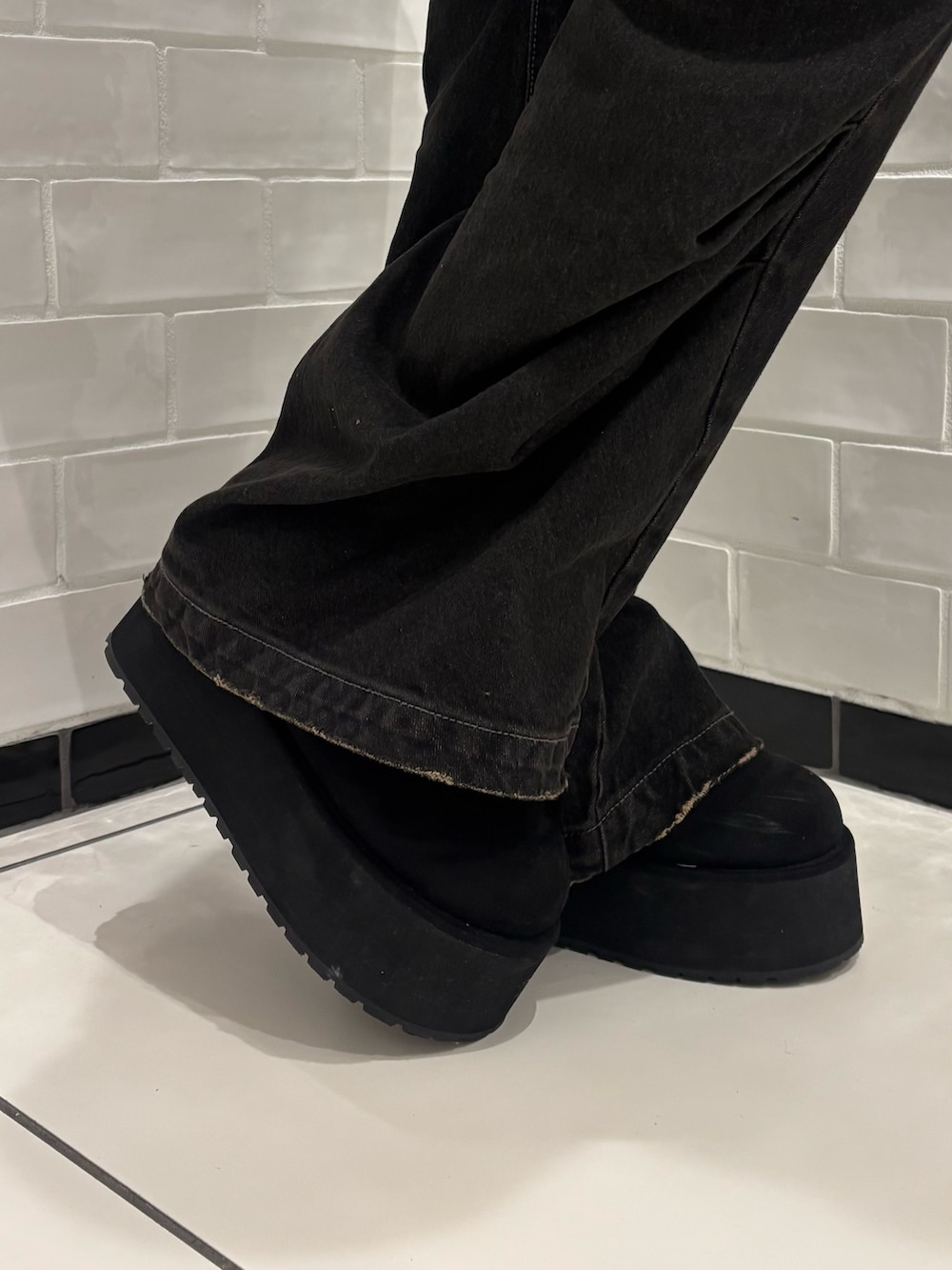 ブラック系のニット/セーター、ブラック系のデニムパンツ、ブラウン系のショルダーバッグを着用したレディースの秋コーディネートの6枚目の写真