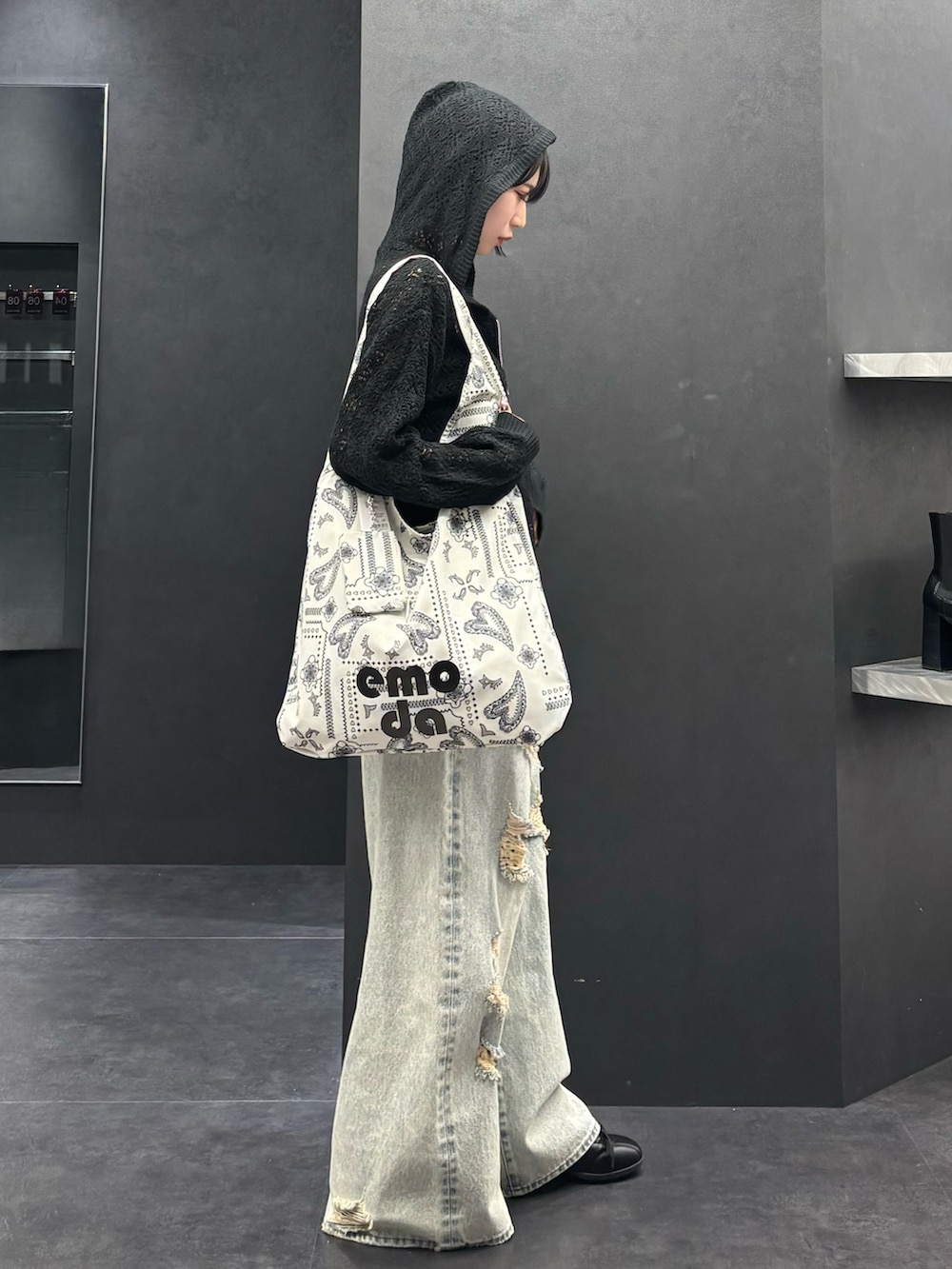 ブラック系のパーカー、ブルー系のデニムパンツ、ブラック系のスニーカーを着用したレディースの春コーディネートの2枚目の写真