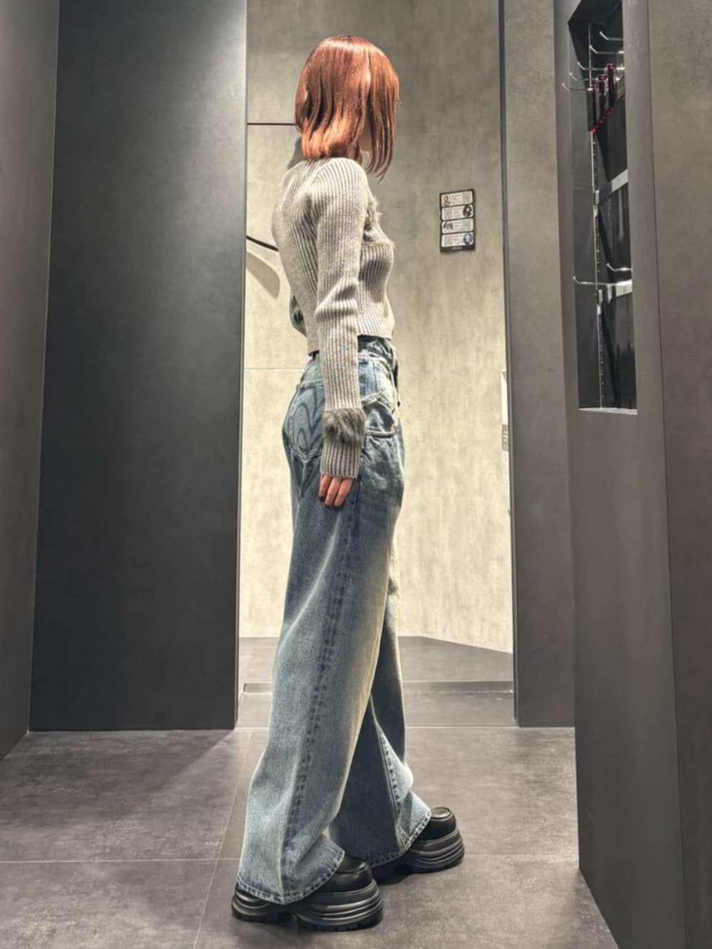 グレー系のニット/セーター、ブルー系のデニムパンツ、ブラック系のローファーを着用したレディースの冬コーディネートの2枚目の写真