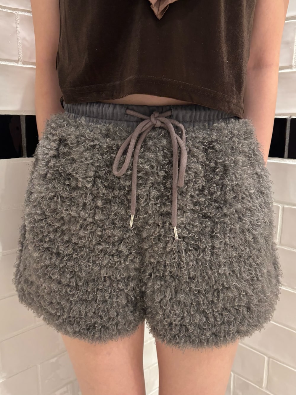 ブラウン系のTシャツ/カットソー、グレー系のその他パンツ、ブラック系のスリッポンを着用したレディースの夏コーディネートの5枚目の写真
