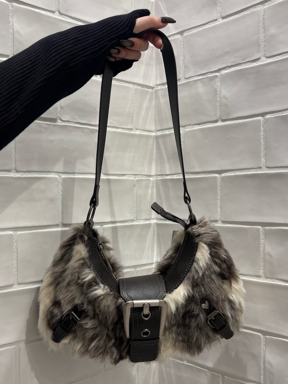 ブラック系のニット/セーター、ブラック系のデニムパンツ、ブラウン系のショルダーバッグを着用したレディースの秋コーディネートの7枚目の写真