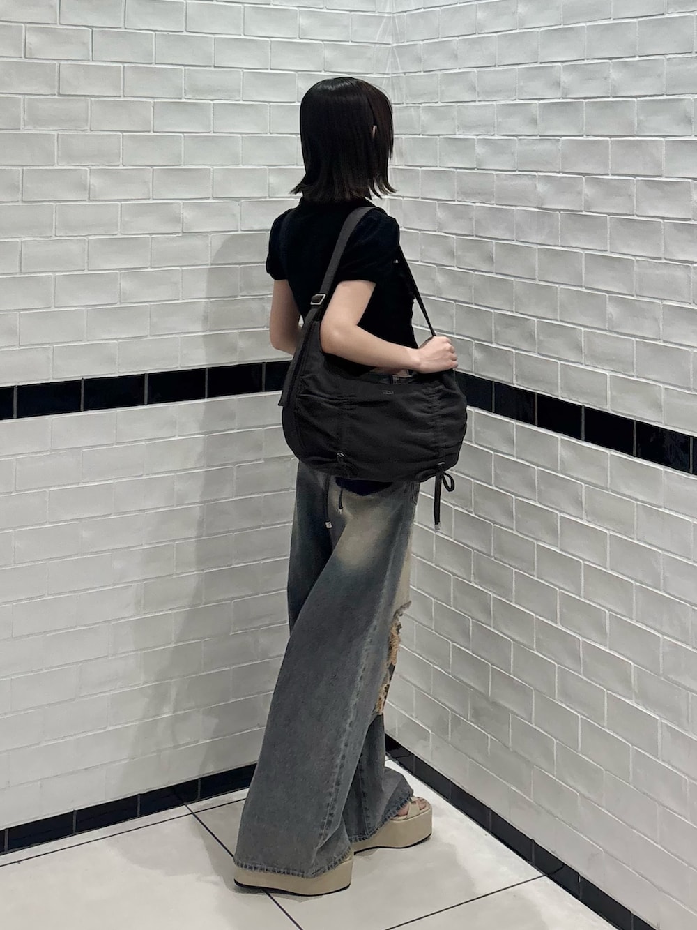 ブラック系のシャツ/ブラウス、ブルー系のデニムパンツ、ホワイト系のサンダルを着用したレディースの夏コーディネートの2枚目の写真