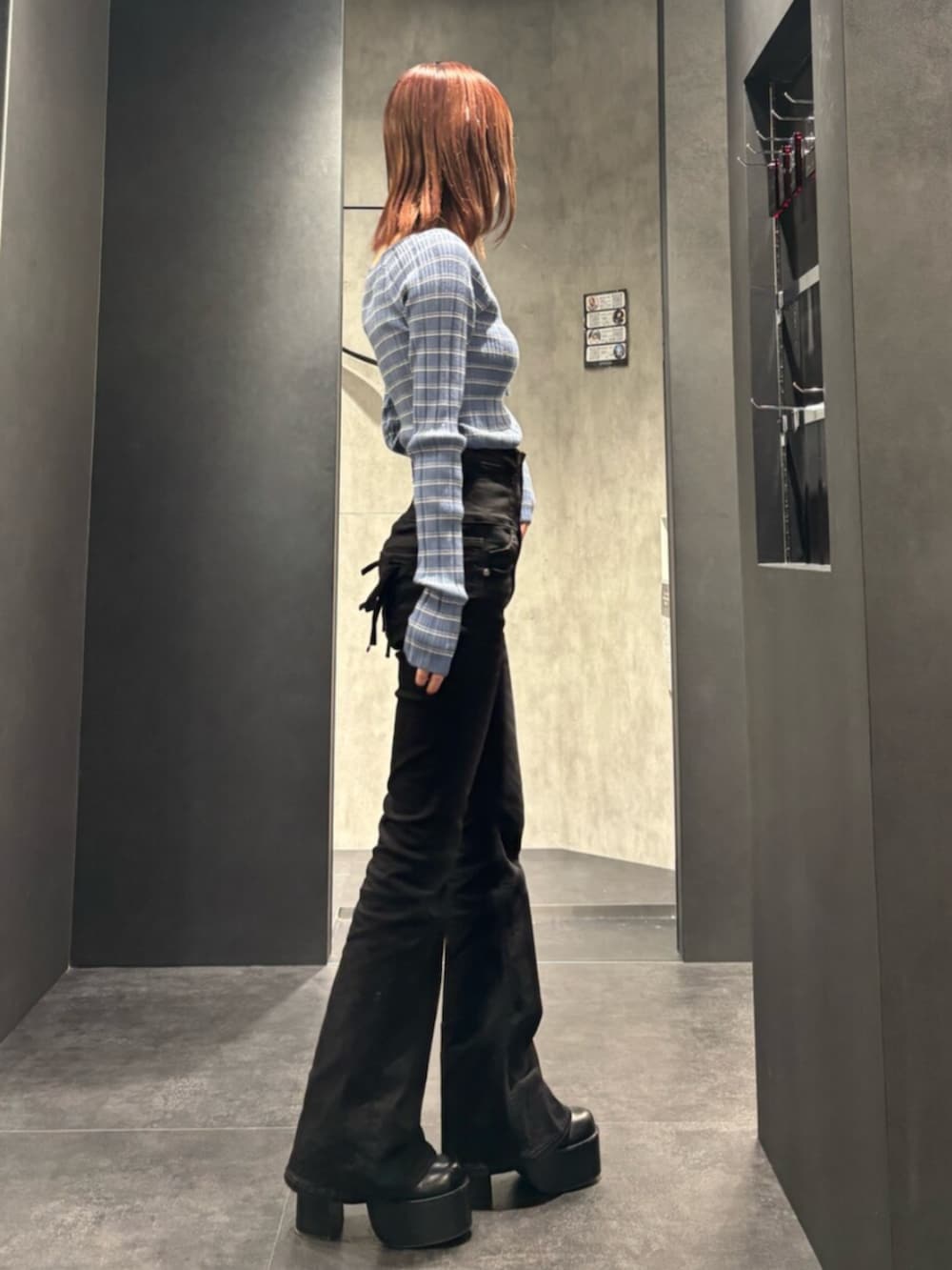 ブラック系のブーツ、ブラック系のデニムパンツ、ブルー系のニット/セーターを着用したレディースの冬コーディネートの2枚目の写真