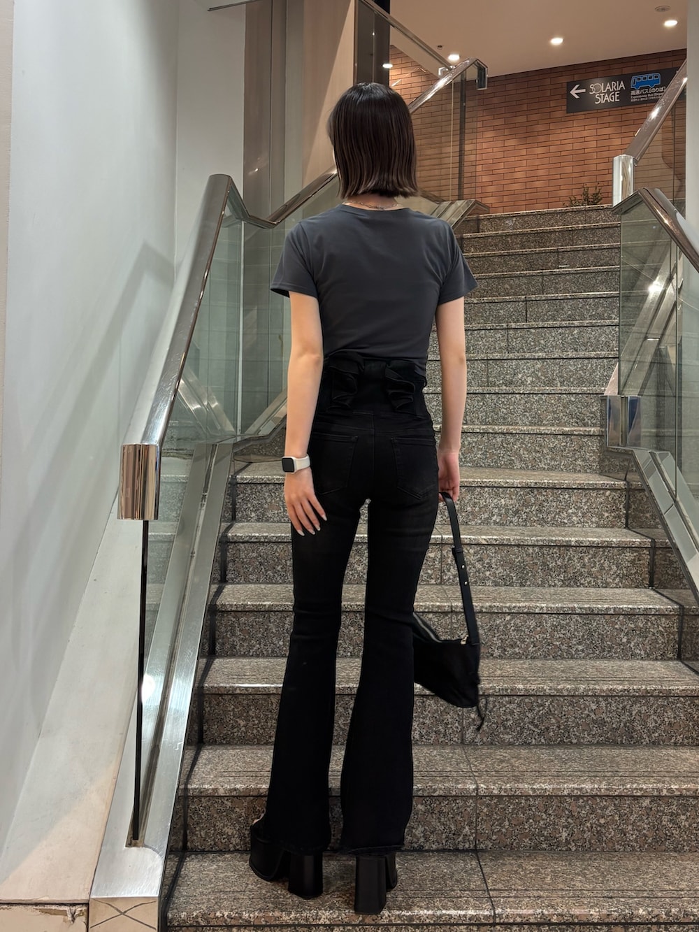 グレー系のTシャツ/カットソー、ブラック系のデニムパンツ、ブラック系のハンドバッグを着用したレディースの春コーディネートの3枚目の写真