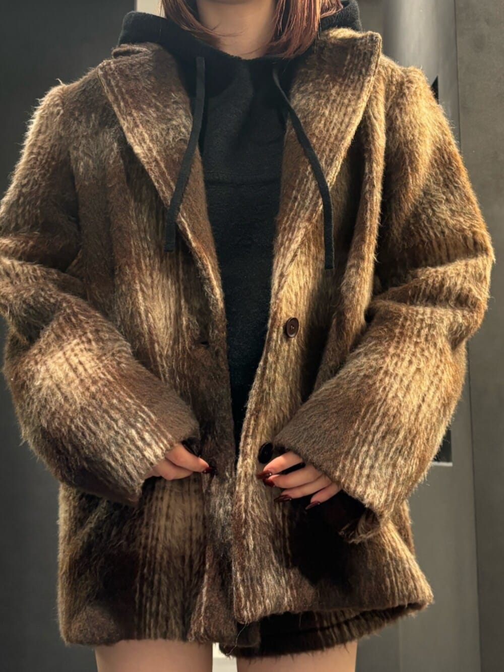 ブラック系のブーツ、ブラウン系のその他アウター、ブラック系のパーカーを着用したレディースの冬コーディネートの5枚目の写真