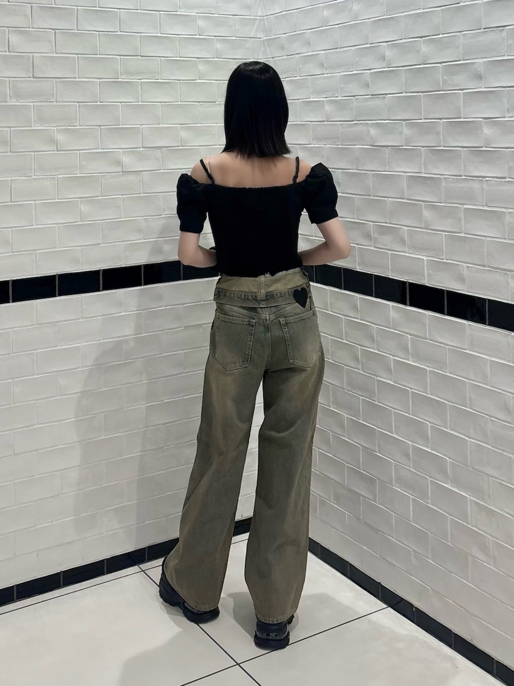 ブラック系のTシャツ/カットソー、ブラウン系のデニムパンツ、ブラック系のスニーカーを着用したレディースの夏コーディネートの3枚目の写真