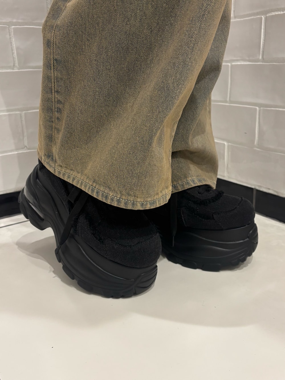 ブラック系のTシャツ/カットソー、ブラウン系のデニムパンツ、ブラック系のスニーカーを着用したレディースの夏コーディネートの7枚目の写真