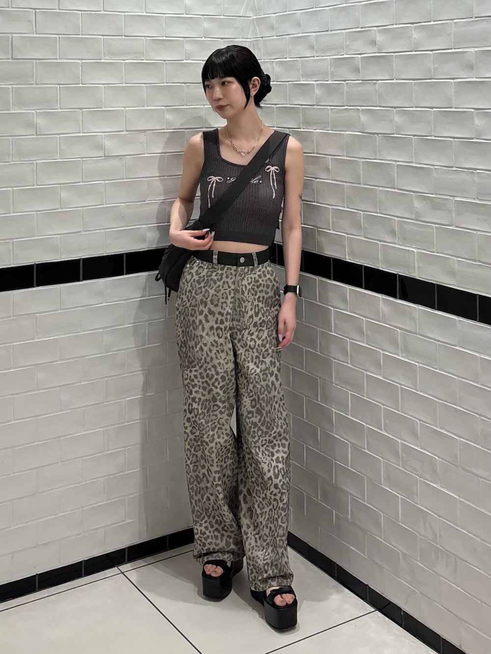 ベージュ系のその他パンツ、ブラック系のサンダル、ブラック系のハンドバッグを着用したレディースの夏コーディネートの4枚目の写真