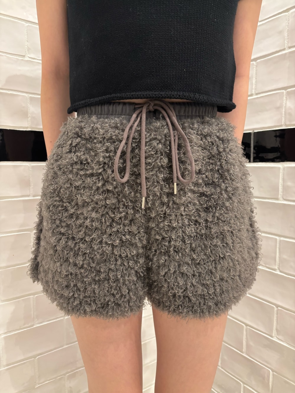 ブラック系のニット/セーター、グレー系のその他パンツ、ブラック系のスリッポンを着用したレディースの夏コーディネートの5枚目の写真