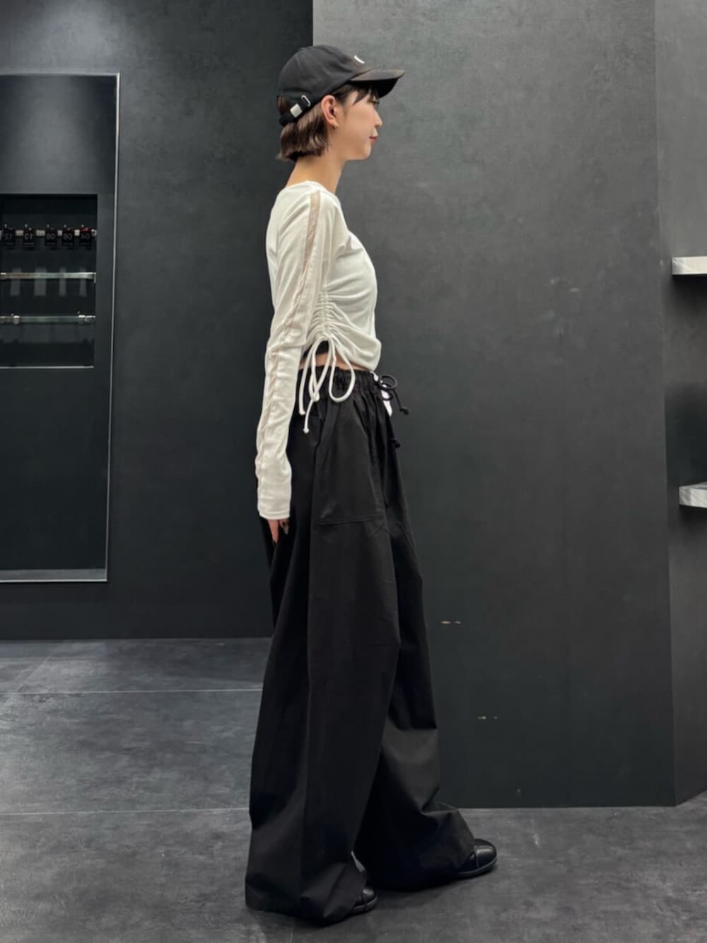 ブラック系のスニーカー、ホワイト系のTシャツ/カットソー、ブラック系のその他パンツを着用したレディースの春コーディネートの3枚目の写真