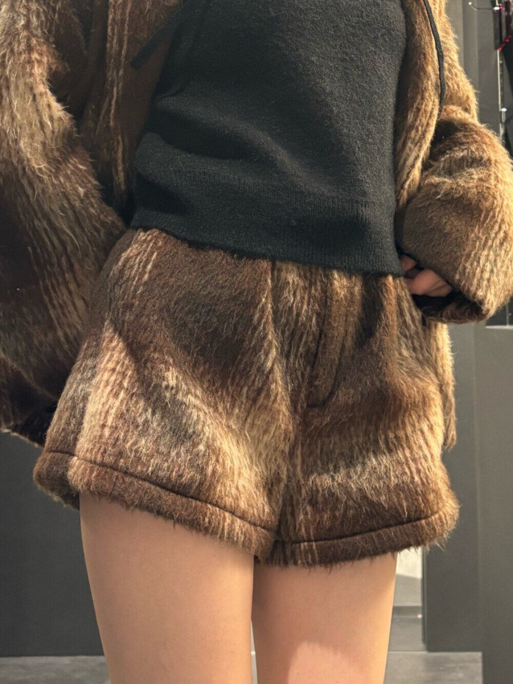 ブラック系のブーツ、ブラウン系のその他アウター、ブラック系のパーカーを着用したレディースの冬コーディネートの6枚目の写真