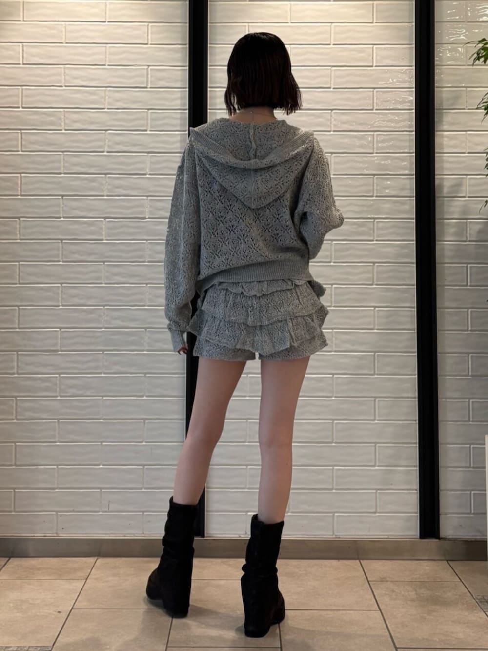 グレー系のパーカー、グレー系のスカート、ブラック系のサンダルを着用したレディースの春コーディネートの3枚目の写真