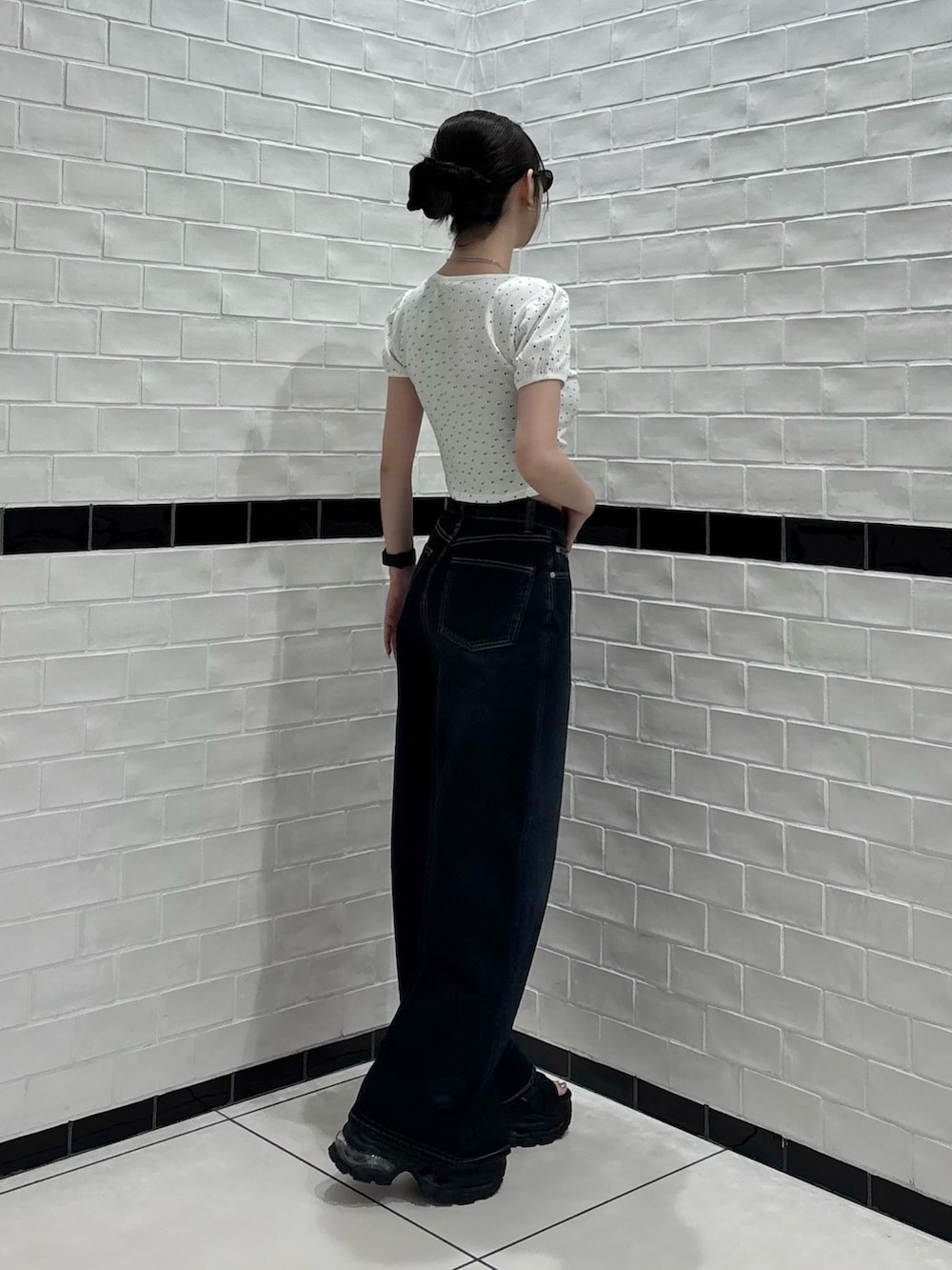 ホワイト系のTシャツ/カットソー、ブルー系のデニムパンツ、ブラック系のサンダルを着用したレディースの夏コーディネートの2枚目の写真