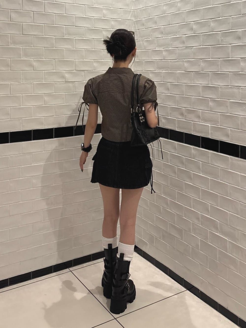 ブラック系のスカート、ブラック系のショルダーバッグ、ブラウン系のTシャツ/カットソーを着用したレディースの夏コーディネートの3枚目の写真