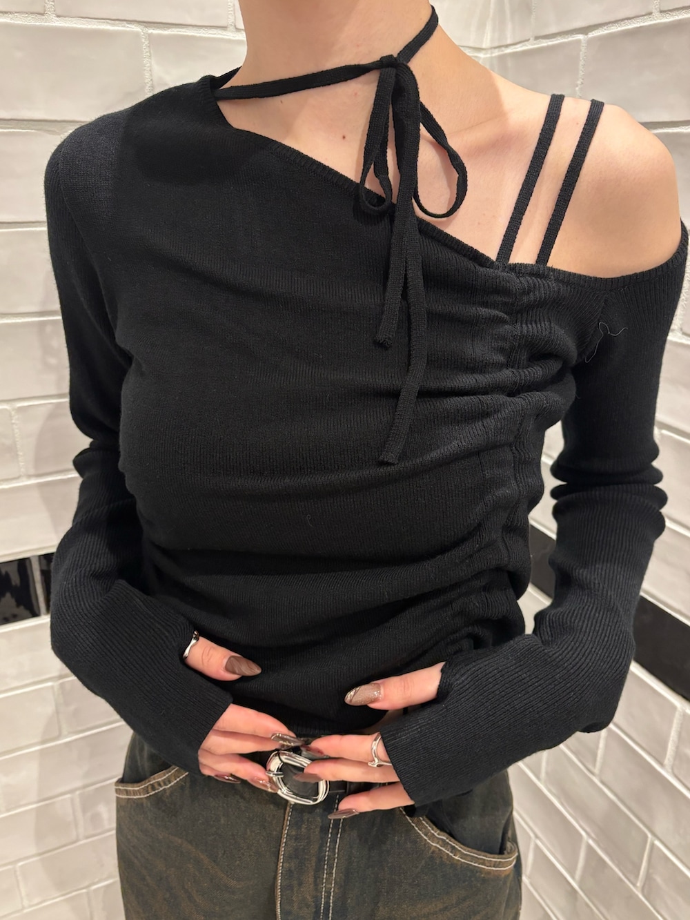 ブラック系のニット/セーター、ブルー系のデニムパンツ、ブラウン系のハンドバッグを着用したレディースの冬コーディネートの4枚目の写真