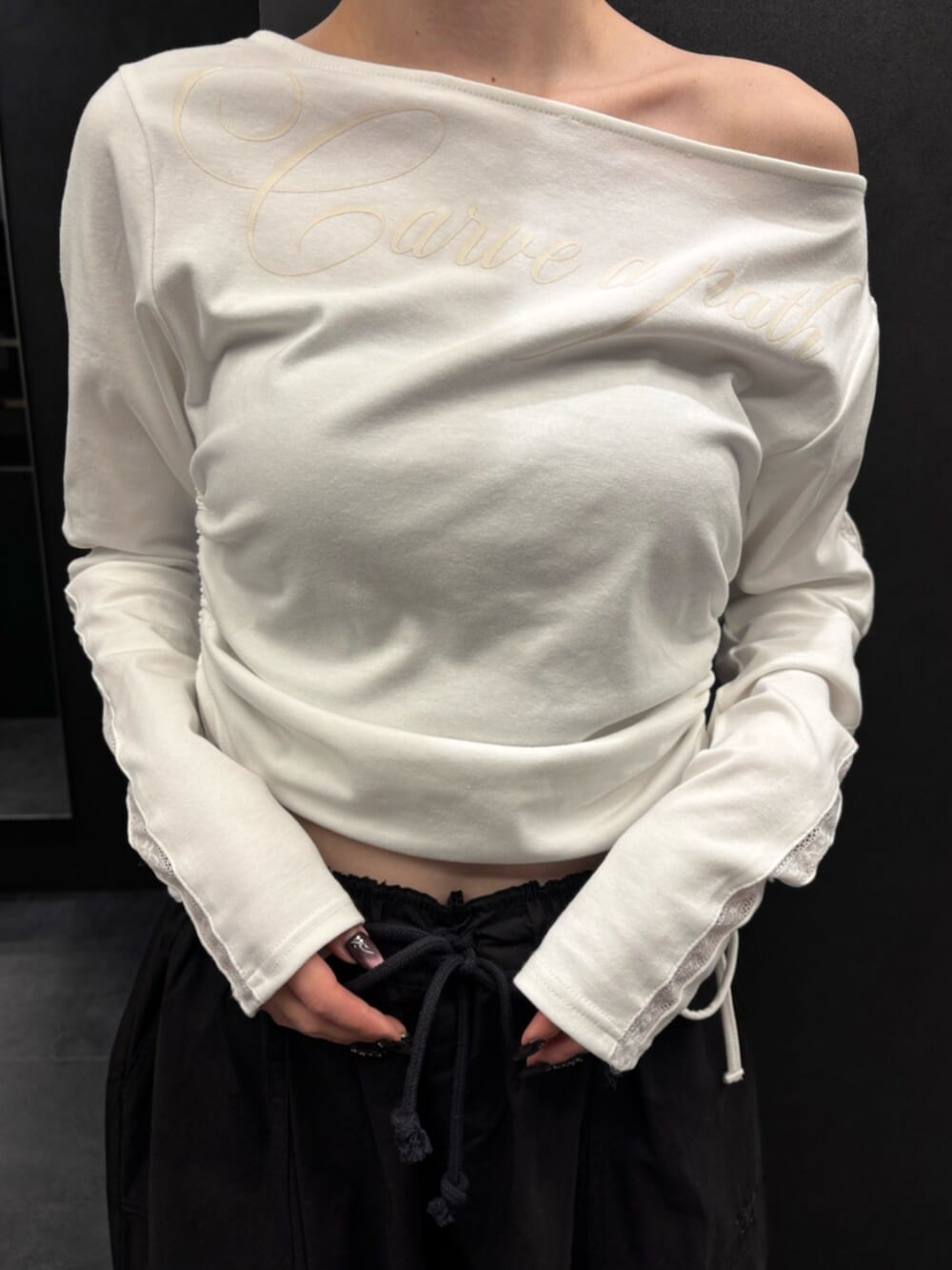 ブラック系のスニーカー、ホワイト系のTシャツ/カットソー、ブラック系のその他パンツを着用したレディースの春コーディネートの5枚目の写真