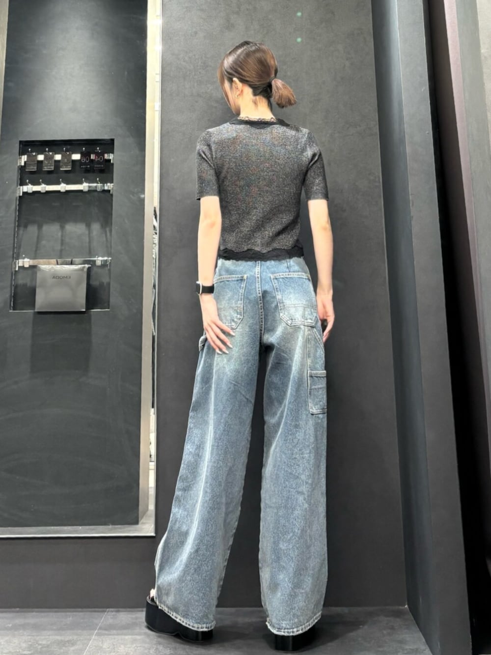 ブラック系のサンダル、ブラック系のニット/セーター、ブルー系のデニムパンツを着用したレディースの春コーディネートの3枚目の写真
