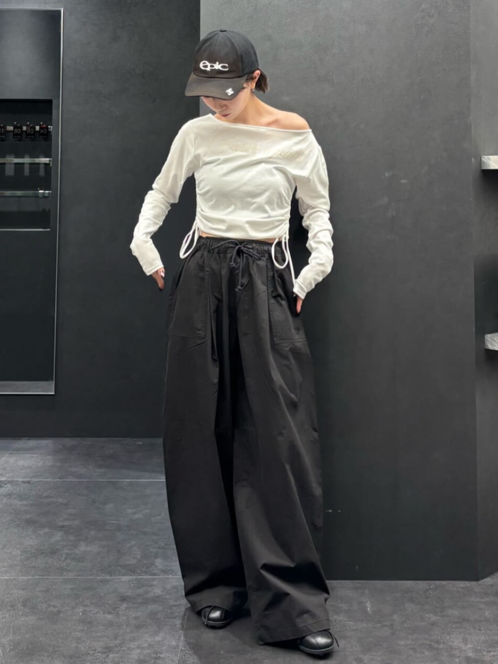 ブラック系のスニーカー、ホワイト系のTシャツ/カットソー、ブラック系のその他パンツを着用したレディースの春コーディネートの2枚目の写真