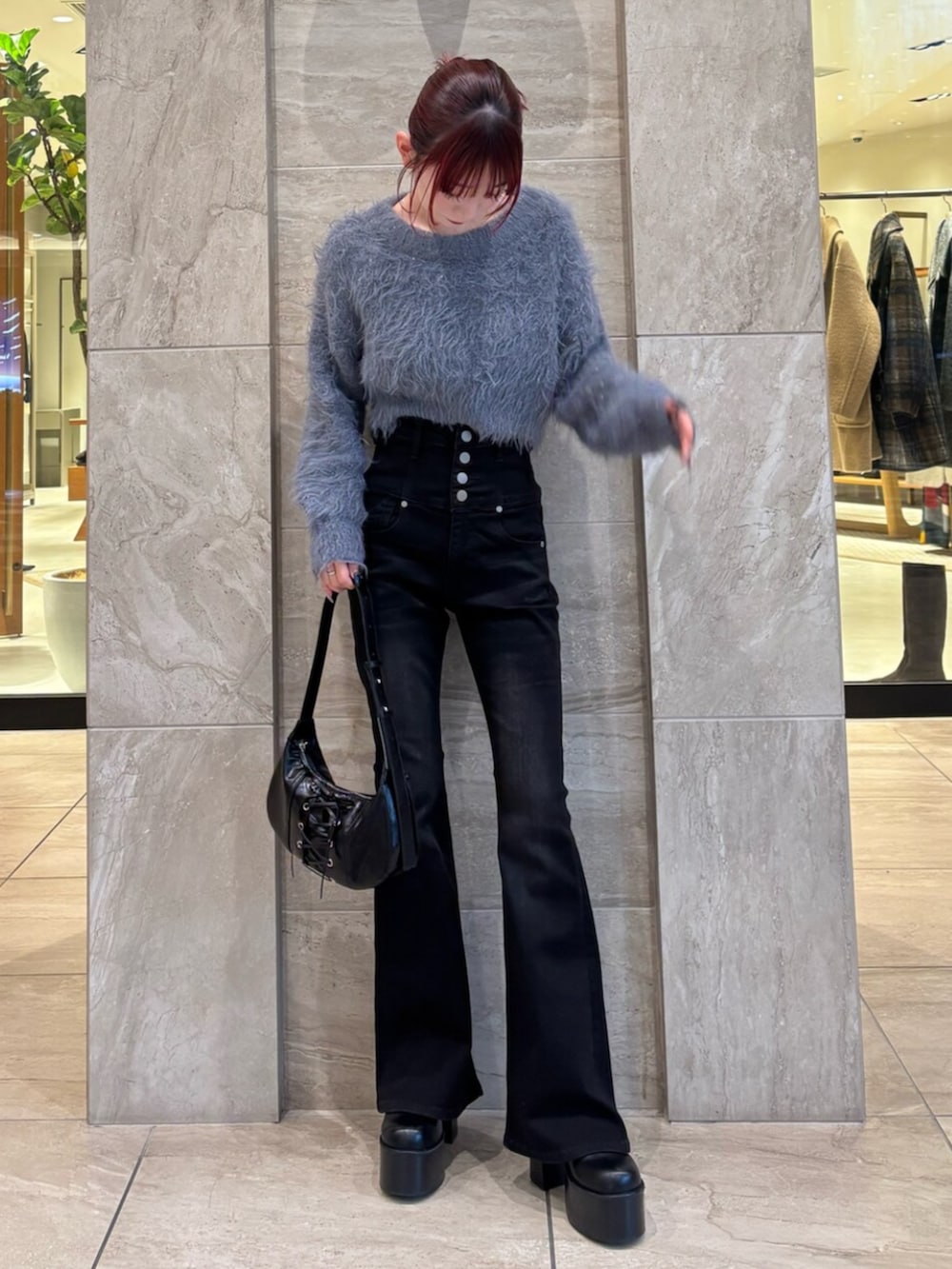 ブラック系のブーツ、グレー系のニット/セーター、ブラック系のデニムパンツを着用したレディースの冬コーディネートの2枚目の写真