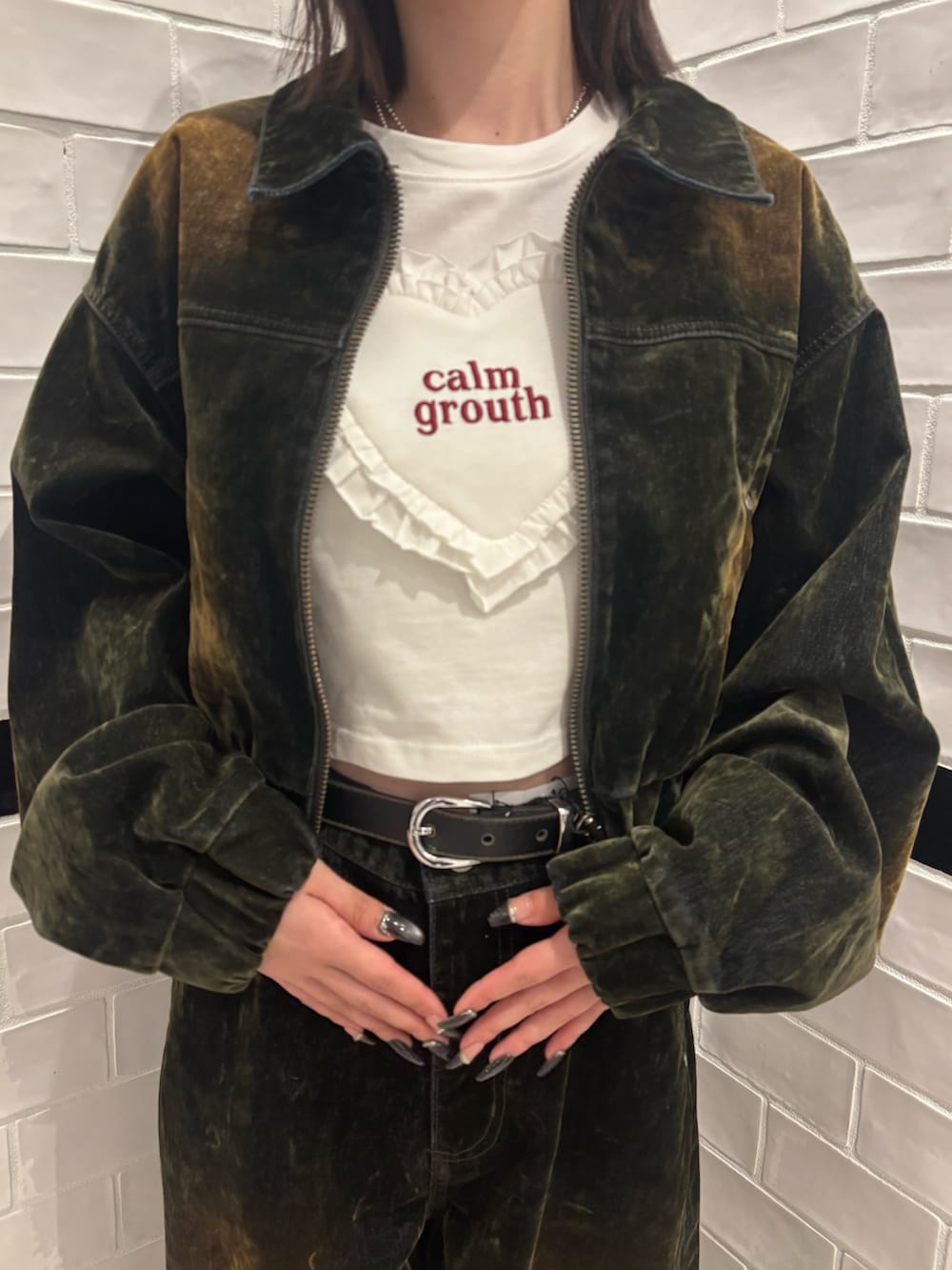 グリーン系のブルゾン、ホワイト系のTシャツ/カットソー、グリーン系のデニムパンツを着用したレディースの夏コーディネートの4枚目の写真