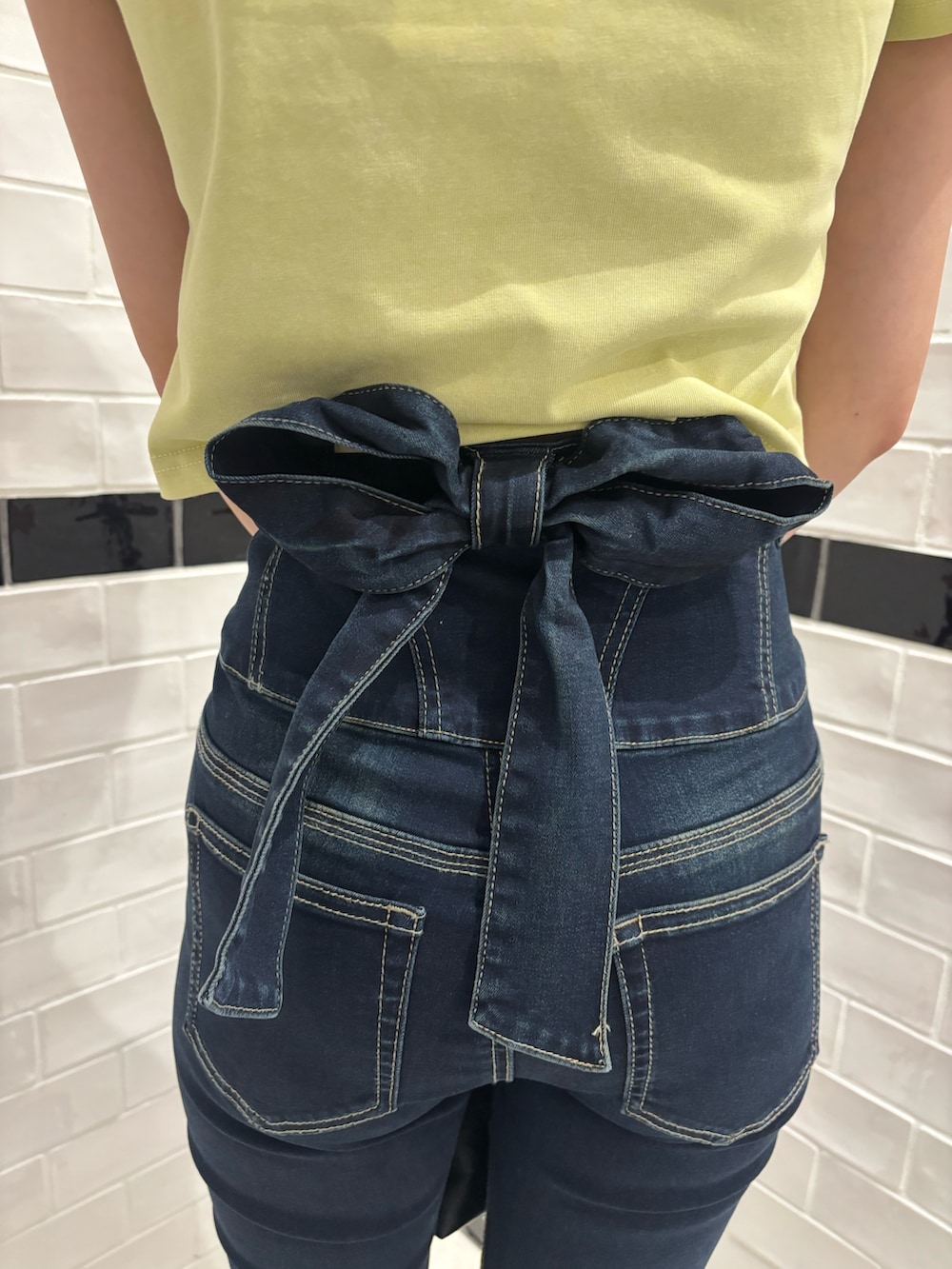 イエロー系のTシャツ/カットソー、ブルー系のデニムパンツ、ブラック系のサンダルを着用したレディースの夏コーディネートの6枚目の写真