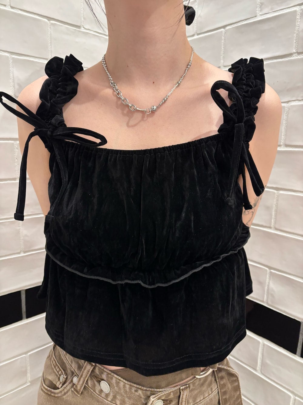 ブラック系のタンクトップ、ブラウン系のデニムパンツ、ブラック系のサンダルを着用したレディースの夏コーディネートの4枚目の写真